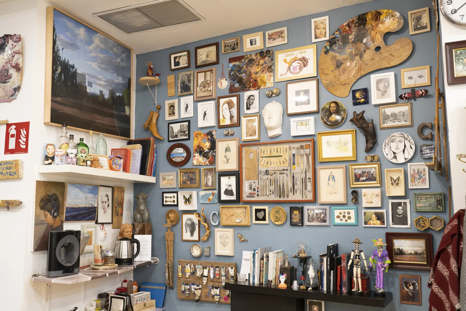 Pared del estudio cubierta de cuadros, paletas y objetos